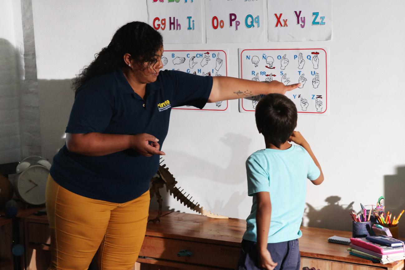 Maestra enseñando lenguaje de señas. 